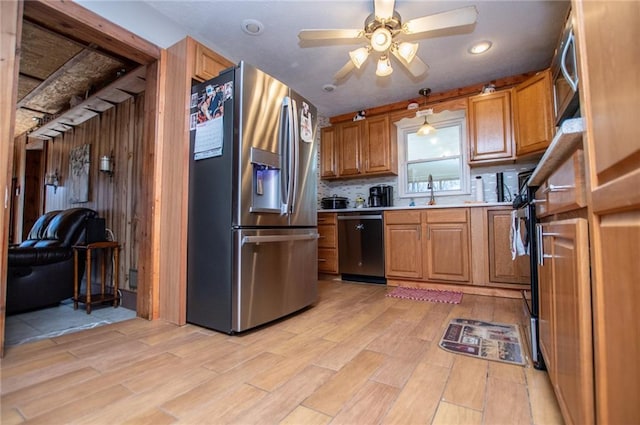 kitchen featuring dishwashing machine, ceiling fan, stainless steel fridge with ice dispenser, decorative light fixtures, and light wood-type flooring