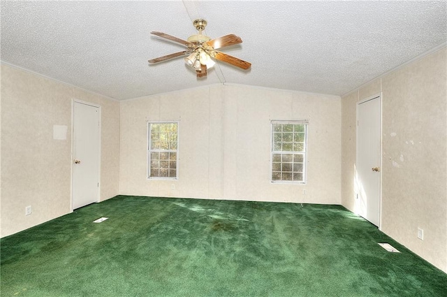 carpeted empty room with a textured ceiling, ceiling fan, and vaulted ceiling