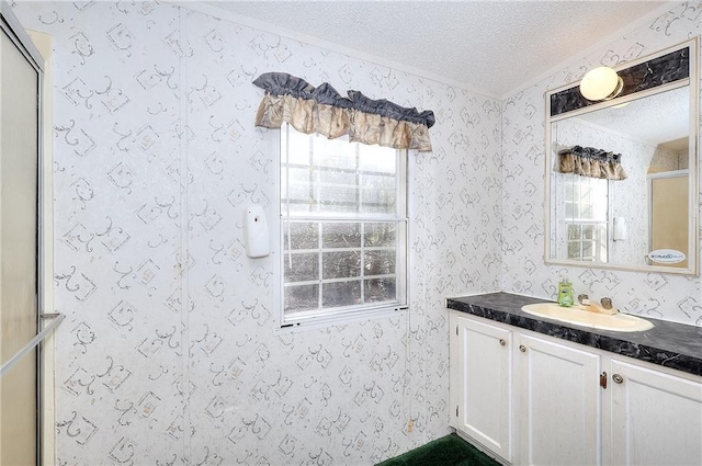 bathroom featuring an enclosed shower, vanity, and a textured ceiling