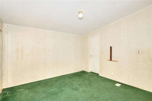 empty room featuring a textured ceiling, dark colored carpet, and crown molding