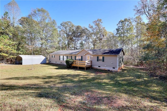 rear view of property with a wooden deck, a carport, and a lawn