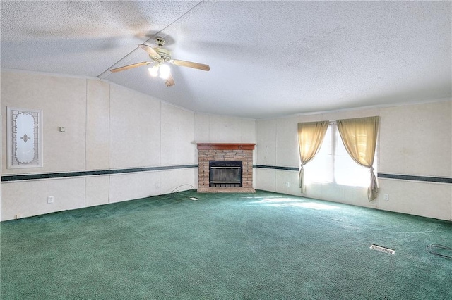 unfurnished living room with lofted ceiling, carpet floors, ceiling fan, and a stone fireplace