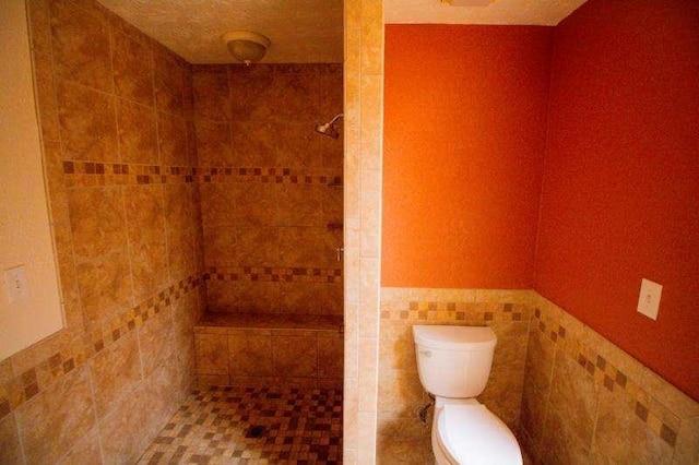 20 Lisa Ct, Stockbridge, GA 30281 - bathroom featuring tiled shower, toilet, tile walls, and wainscoting