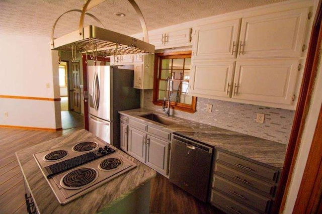 20 Lisa Ct, Stockbridge, GA 30281 - kitchen with appliances with stainless steel finishes, dark wood finished floors, a sink, a textured ceiling, and decorative backsplash