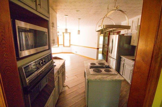 20 Lisa Ct, Stockbridge, GA 30281 - kitchen with stainless steel appliances, dark wood-type flooring, hanging light fixtures, and light countertops