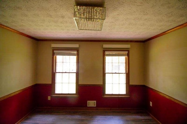 20 Lisa Ct, Stockbridge, GA 30281 - empty room with healthy amount of natural light, a textured ceiling, wood finished floors, ornamental molding, and baseboards