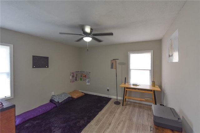 bedroom with ceiling fan, wood finished floors, and baseboards