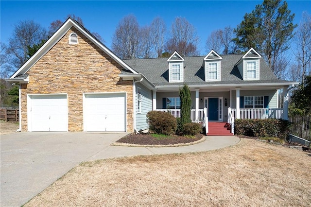 view of front of home with roof with shingles, an attached garage, covered porch, concrete driveway, and stone siding