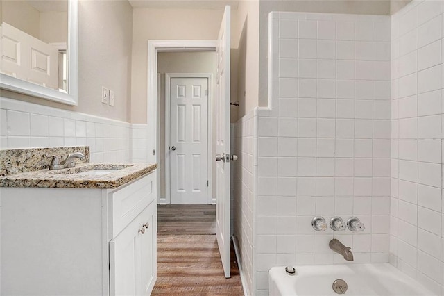 3204 Robin Rd, Decatur, GA 30032 - bathroom with tile walls, vanity, wood finished floors, wainscoting, and shower / bathtub combination