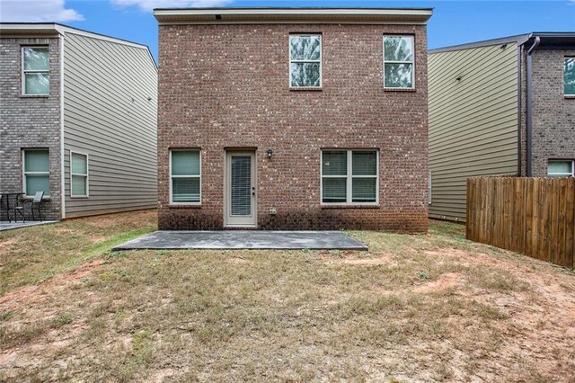 rear view of property featuring a yard and a patio area