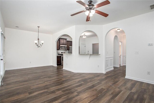 unfurnished living room featuring dark hardwood / wood-style floors and ceiling fan with notable chandelier