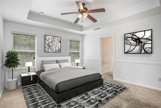 carpeted bedroom featuring ceiling fan, multiple windows, a raised ceiling, and crown molding