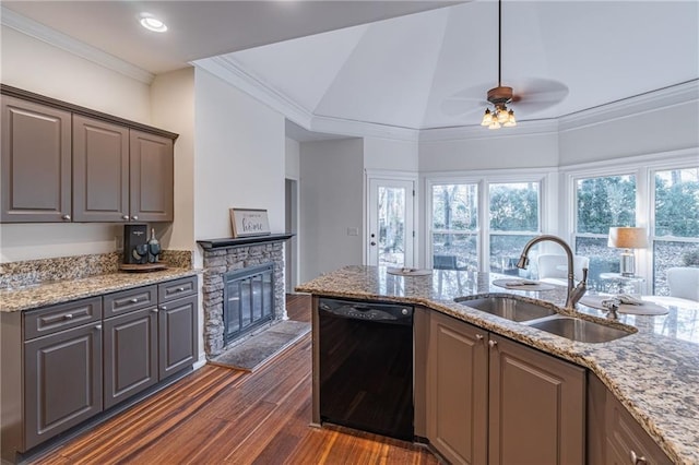 kitchen with a stone fireplace, dishwasher, dark hardwood / wood-style floors, sink, and lofted ceiling