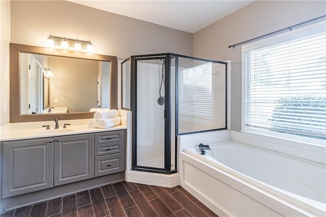 bathroom with independent shower and bath and vanity