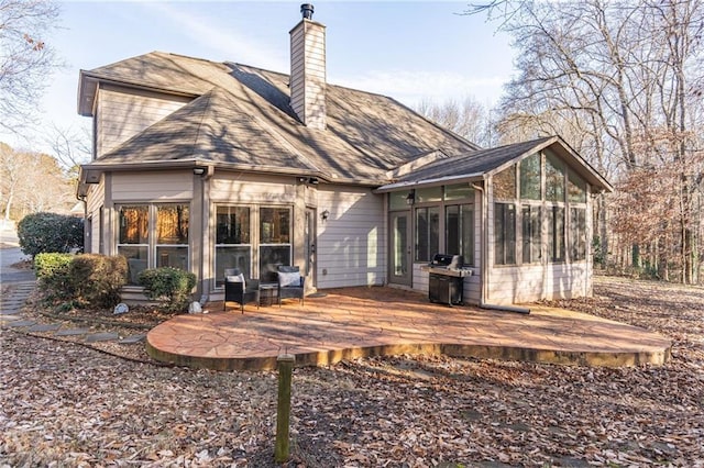 rear view of property with a deck and a sunroom