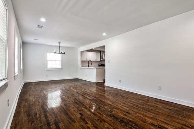 2195 Penelope St NW, Atlanta, GA 30314 - unfurnished living room featuring an inviting chandelier, visible vents, baseboards, a sink, and dark wood finished floors