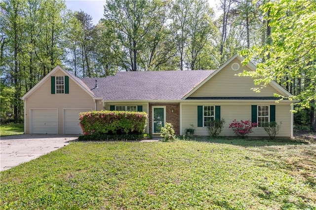 single story home with a garage, a front yard, and concrete driveway