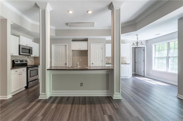 kitchen featuring stainless steel appliances, decorative columns, decorative backsplash, and dark wood finished floors