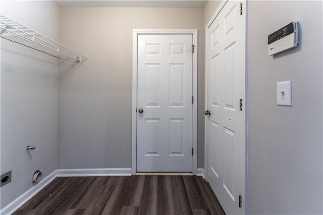 clothes washing area featuring baseboards, laundry area, hookup for an electric dryer, and dark wood finished floors