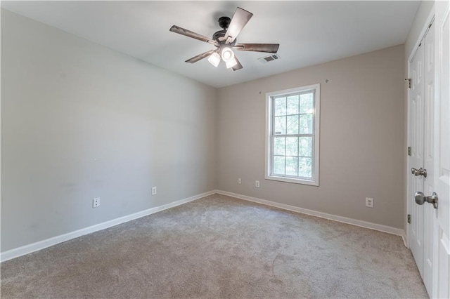 empty room featuring ceiling fan, baseboards, carpet flooring, and visible vents
