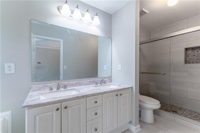 bathroom featuring a shower stall, toilet, a sink, and visible vents