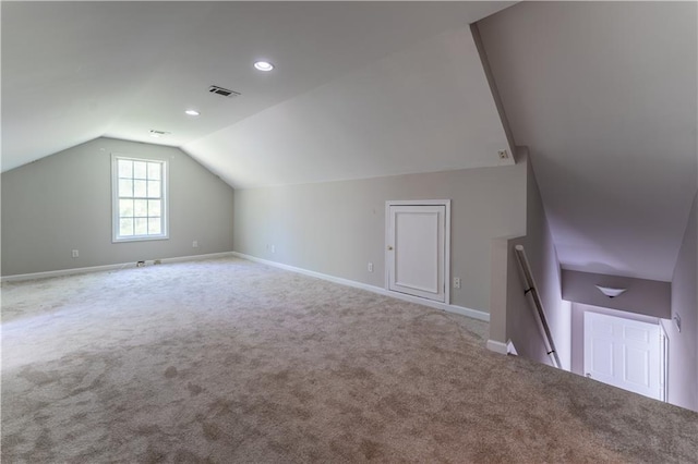 additional living space with baseboards, lofted ceiling, visible vents, and carpet floors