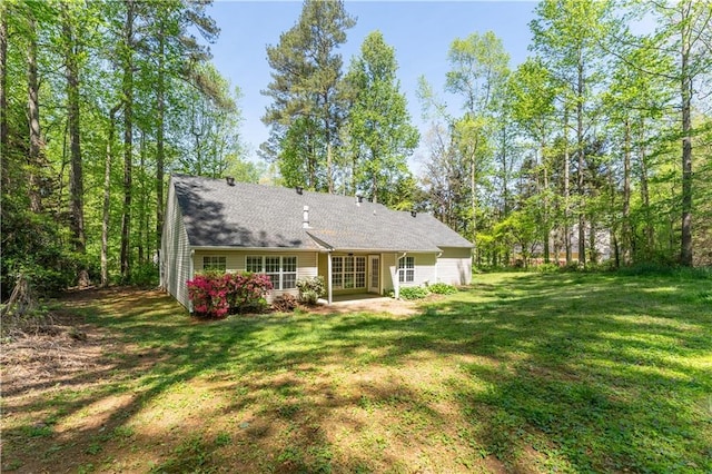 rear view of property featuring a yard