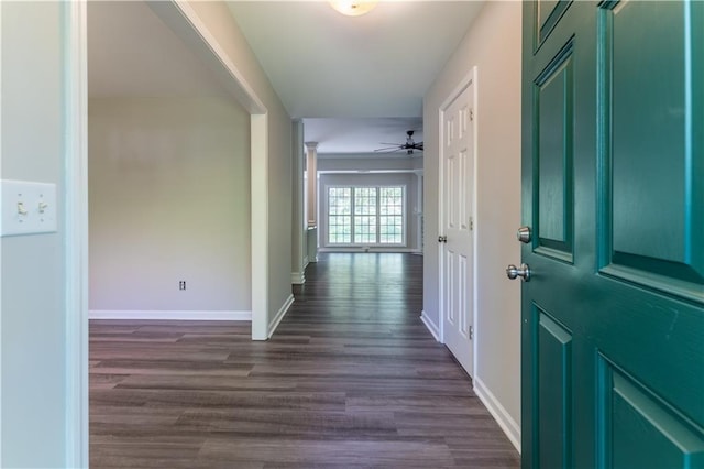 hall featuring baseboards and dark wood-style flooring
