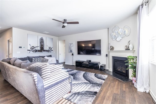 living room featuring ceiling fan and dark wood-type flooring