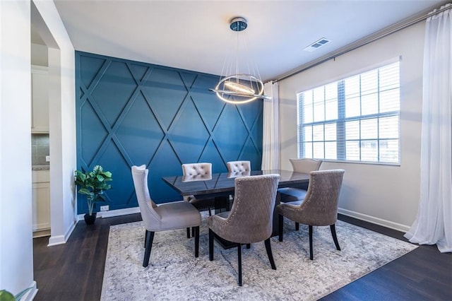 dining area featuring dark hardwood / wood-style floors and an inviting chandelier