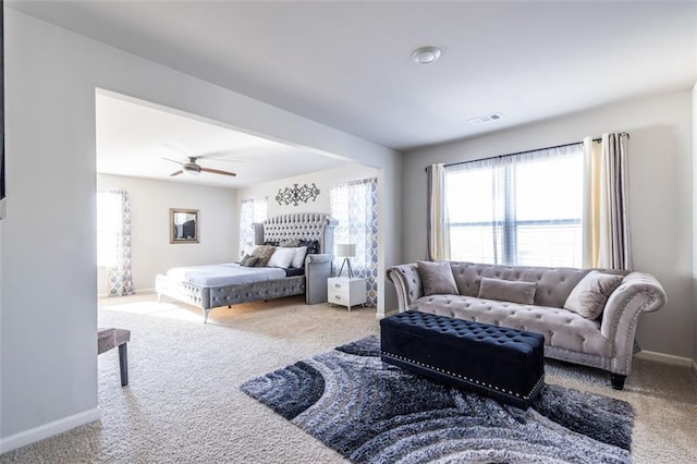 carpeted bedroom with ceiling fan and multiple windows