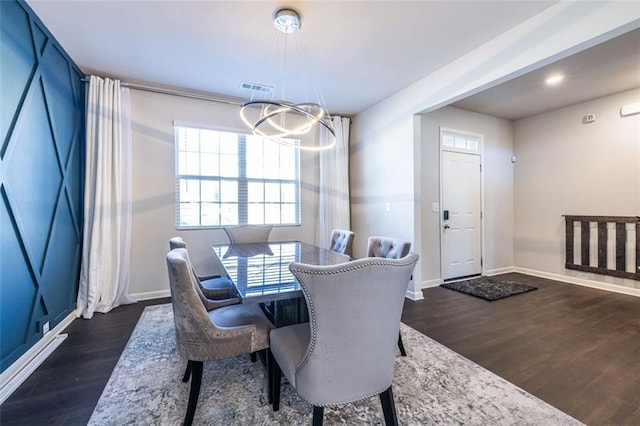 dining area featuring an inviting chandelier and dark wood-type flooring