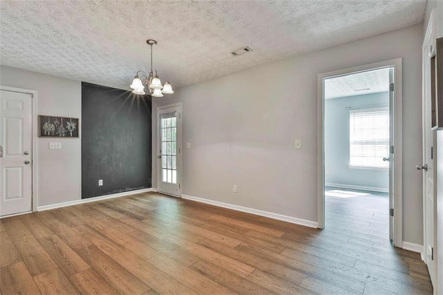 2551 Luther Bailey Rd, Senoia, GA 30276 - empty room featuring a textured ceiling, hardwood / wood-style floors, a chandelier, and healthy amount of natural light