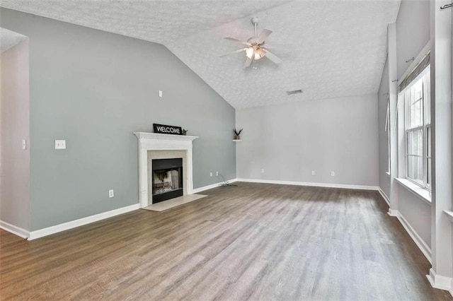 2551 Luther Bailey Rd, Senoia, GA 30276 - unfurnished living room with a textured ceiling, a ceiling fan, wood finished floors, a fireplace with flush hearth, and lofted ceiling