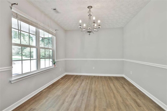 2551 Luther Bailey Rd, Senoia, GA 30276 - unfurnished room featuring wood finished floors, a chandelier, and a textured ceiling