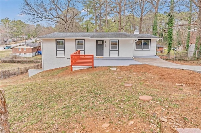 ranch-style home featuring a porch, brick siding, fence, a front lawn, and a chimney