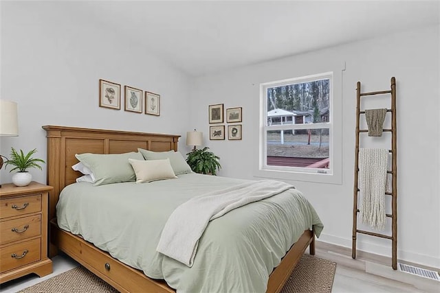 bedroom with light wood-style flooring and baseboards