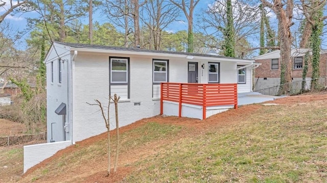 view of front of property with a front lawn, fence, brick siding, and covered porch