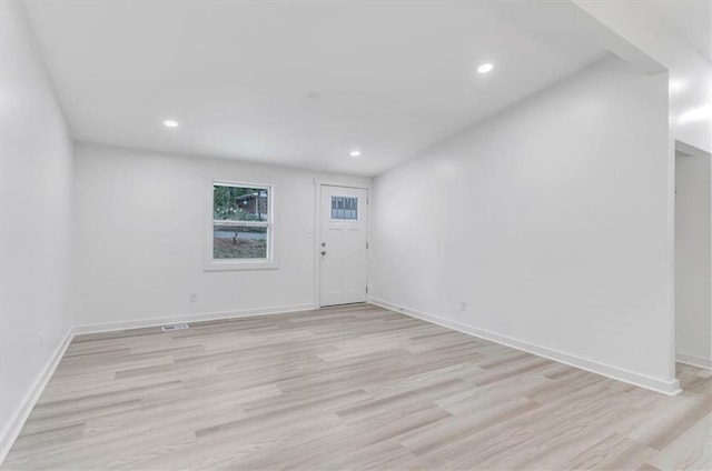 spare room featuring recessed lighting, baseboards, and light wood finished floors