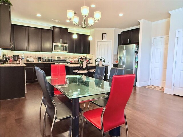 dining space featuring dark wood-style flooring, visible vents, a chandelier, crown molding, and recessed lighting