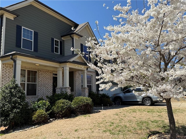 view of front facade with brick siding, a garage, and a front yard
