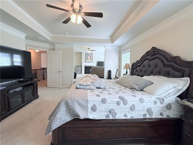 bedroom with ornamental molding, a raised ceiling, light carpet, and a ceiling fan