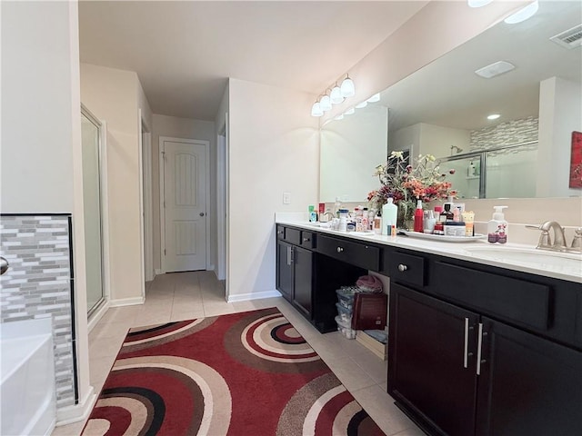 full bathroom with visible vents, a shower stall, double vanity, tile patterned floors, and a sink