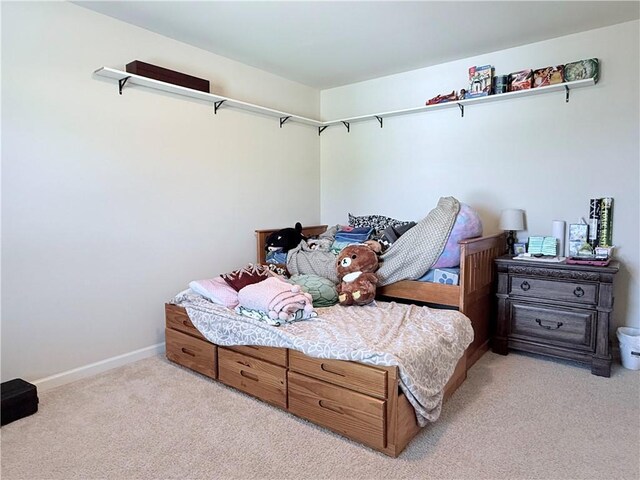 bedroom with light colored carpet and baseboards