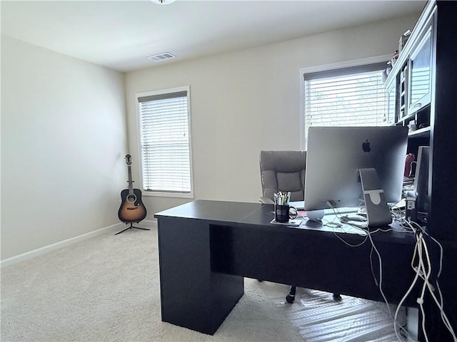 carpeted home office with baseboards, visible vents, and plenty of natural light