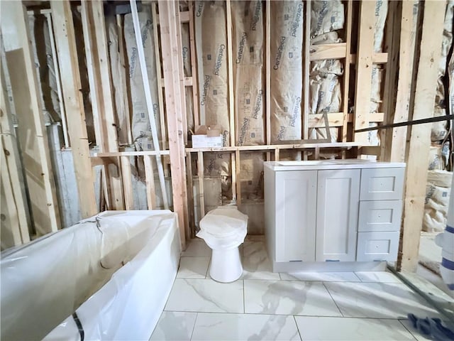full bathroom featuring a bath, marble finish floor, and vanity
