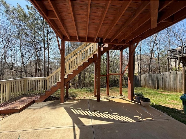 view of patio featuring fence and stairway