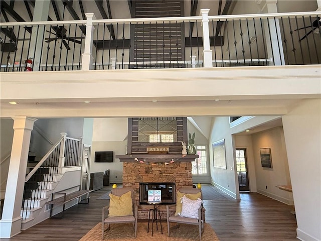 living room featuring stairs, a high ceiling, wood finished floors, and ceiling fan
