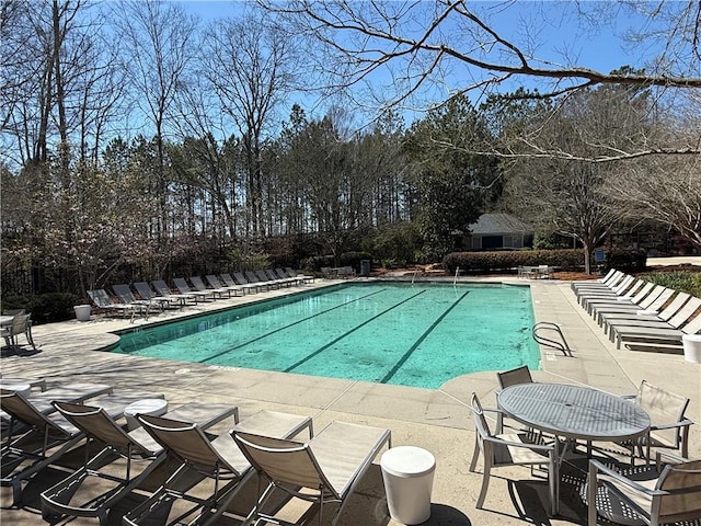 community pool featuring fence and a patio area