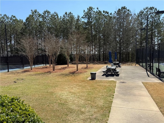 surrounding community with a patio, fence, and a lawn